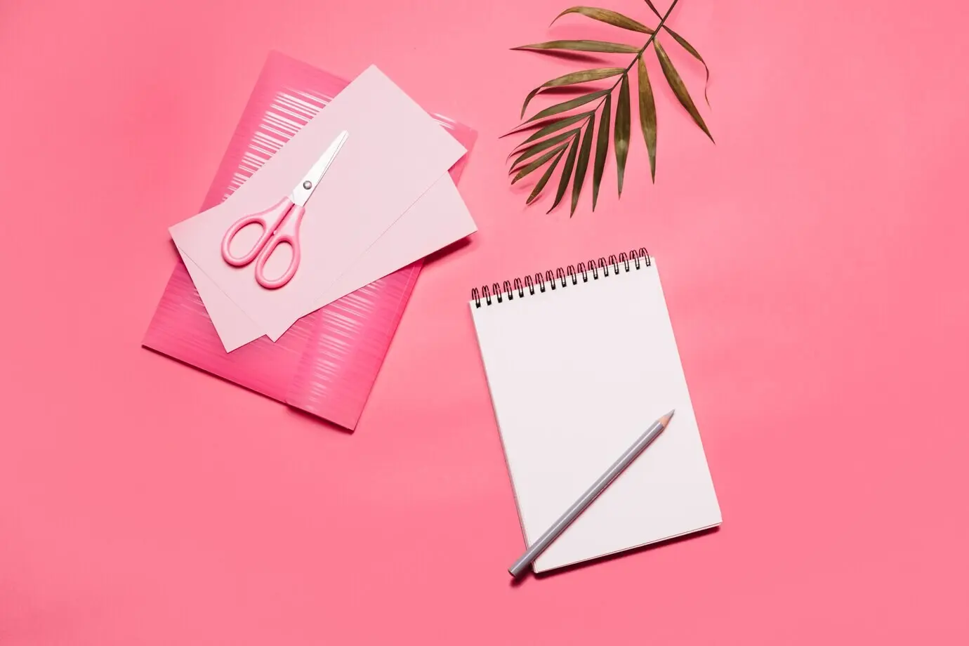 Pink-themed composition featuring a notepad and papers